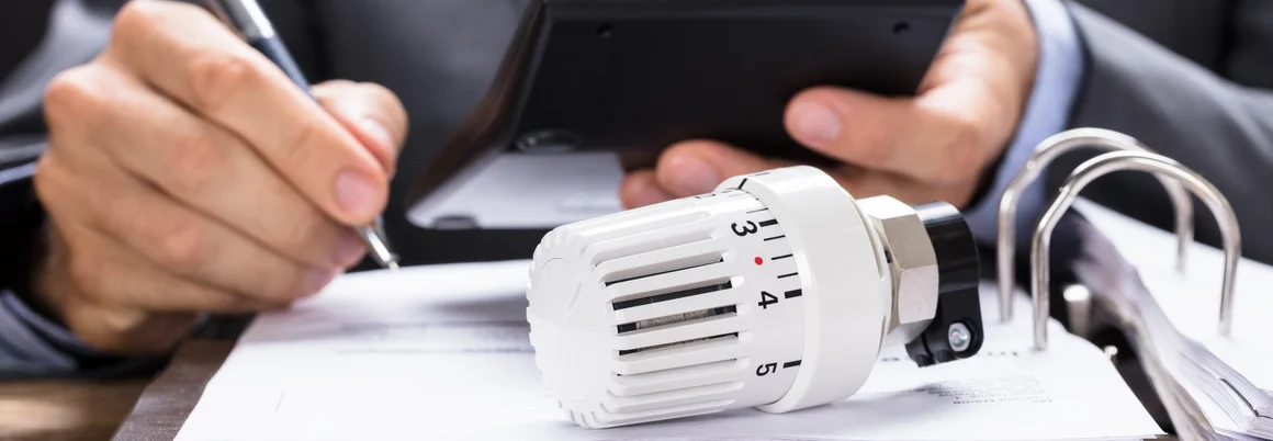 Person berechnet Heizkosten mit Taschenrechner